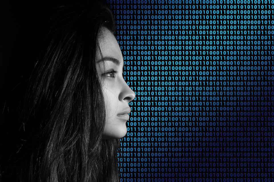 A woman looking sideways and there is binary code in the background
