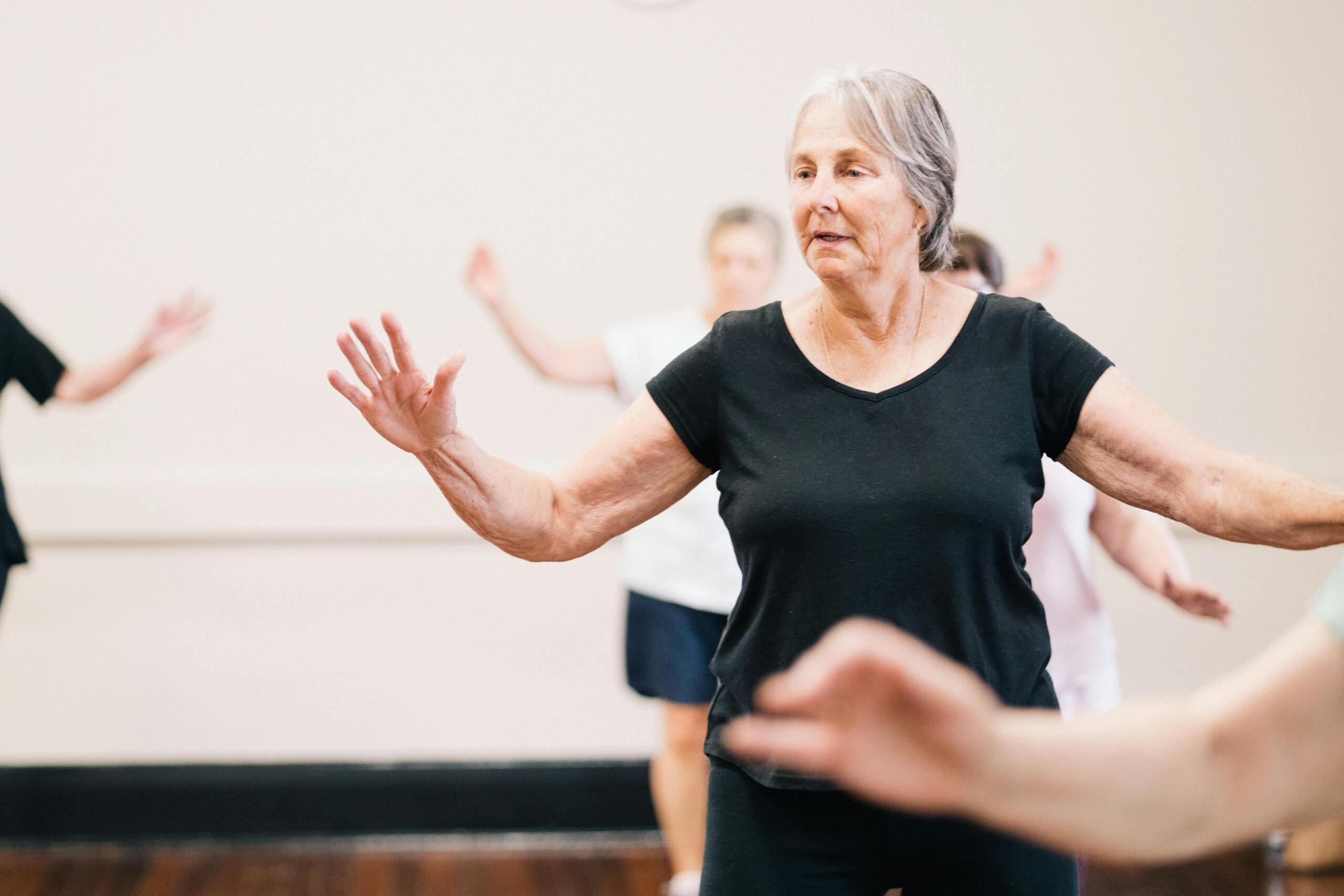 A group of elderly individuals joyfully dancing together, showcasing a vibrant display of movement and energy.