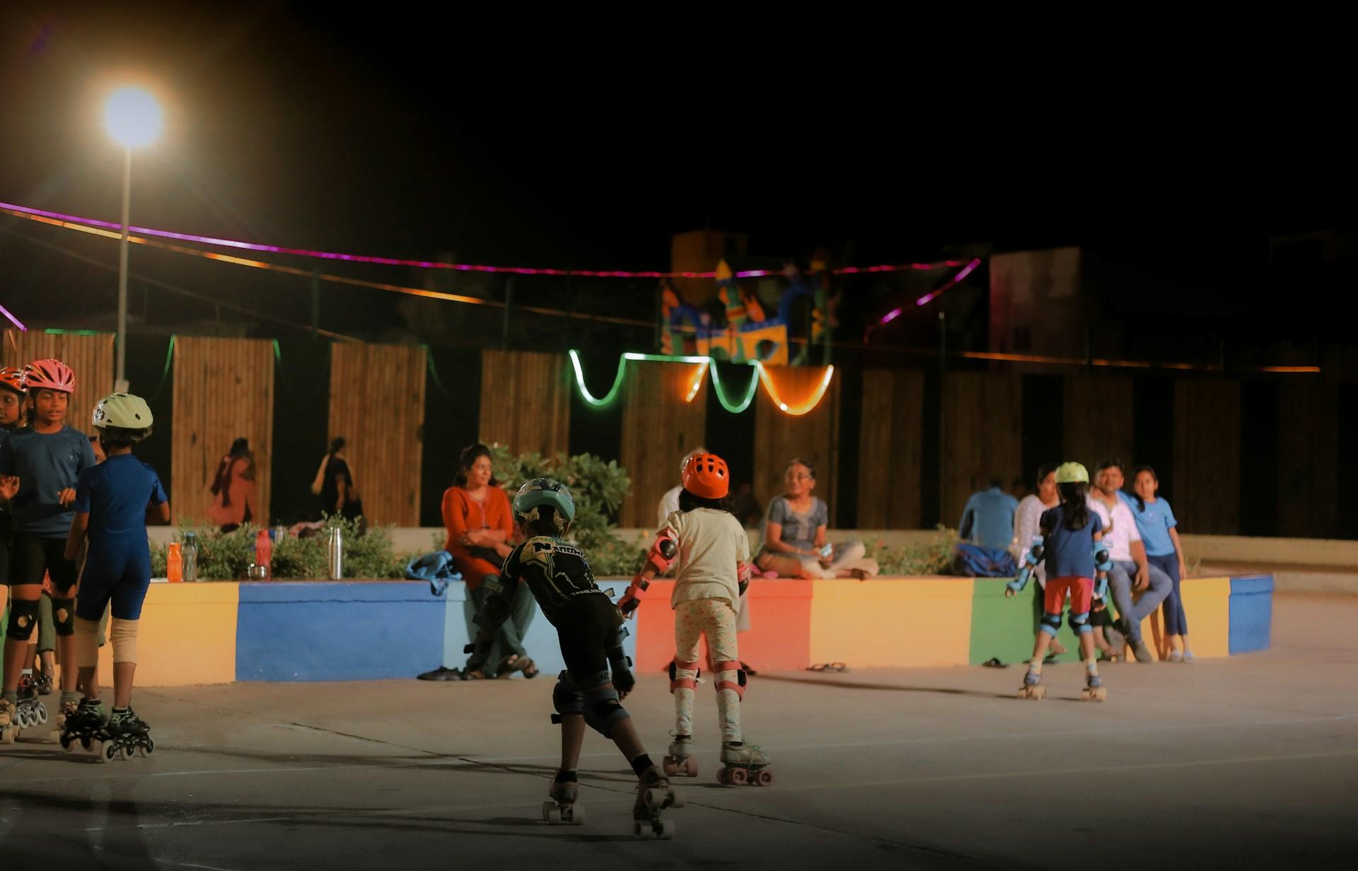 A group of kids roller skating at the skate park.