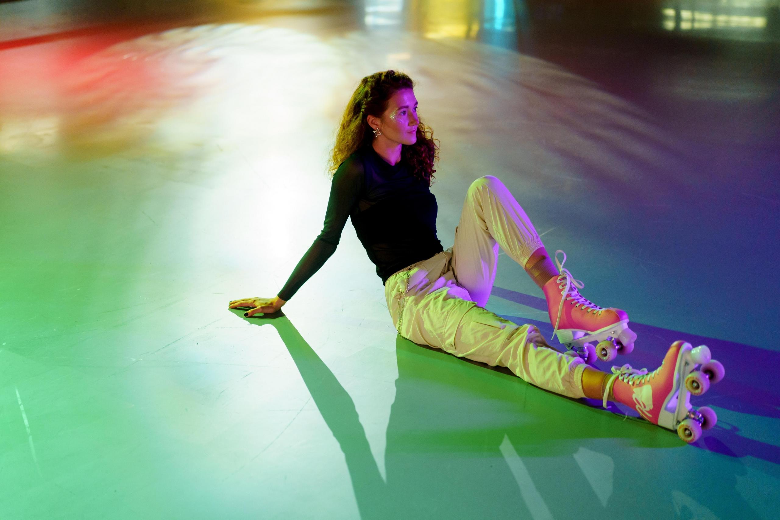 Someone sitting on the floor in their roller skates