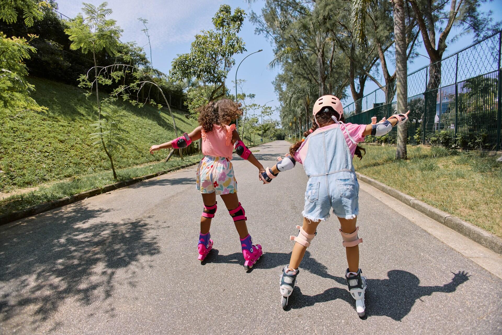 Two girls holding hands and roller skating