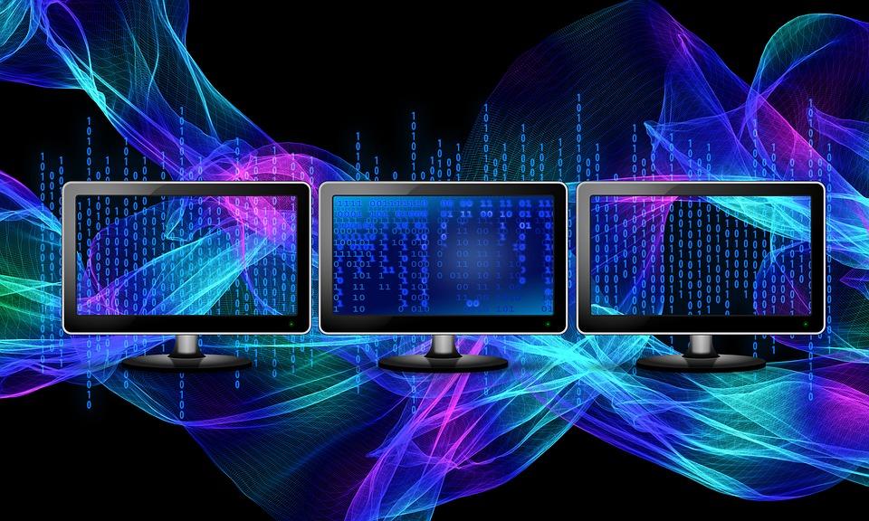 Three monitors showing data complicated data encoded/stored in a binary