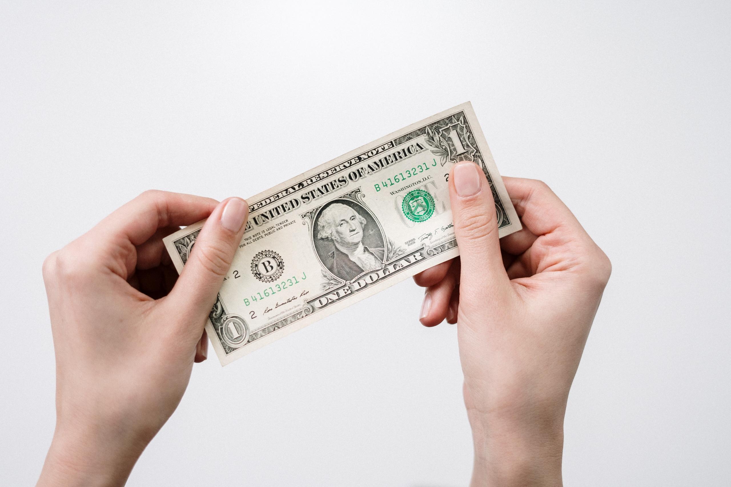 someone holding a dollar bill