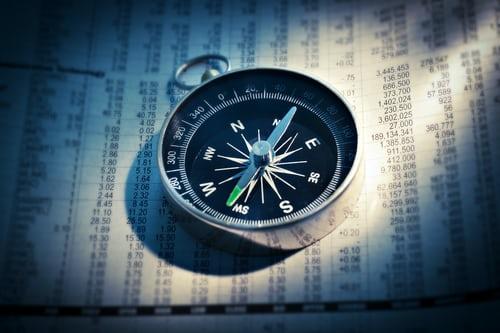 A compass resting on a financial overview