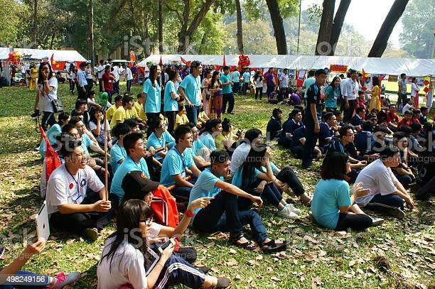 Students sitting under the sky cheering their sports team