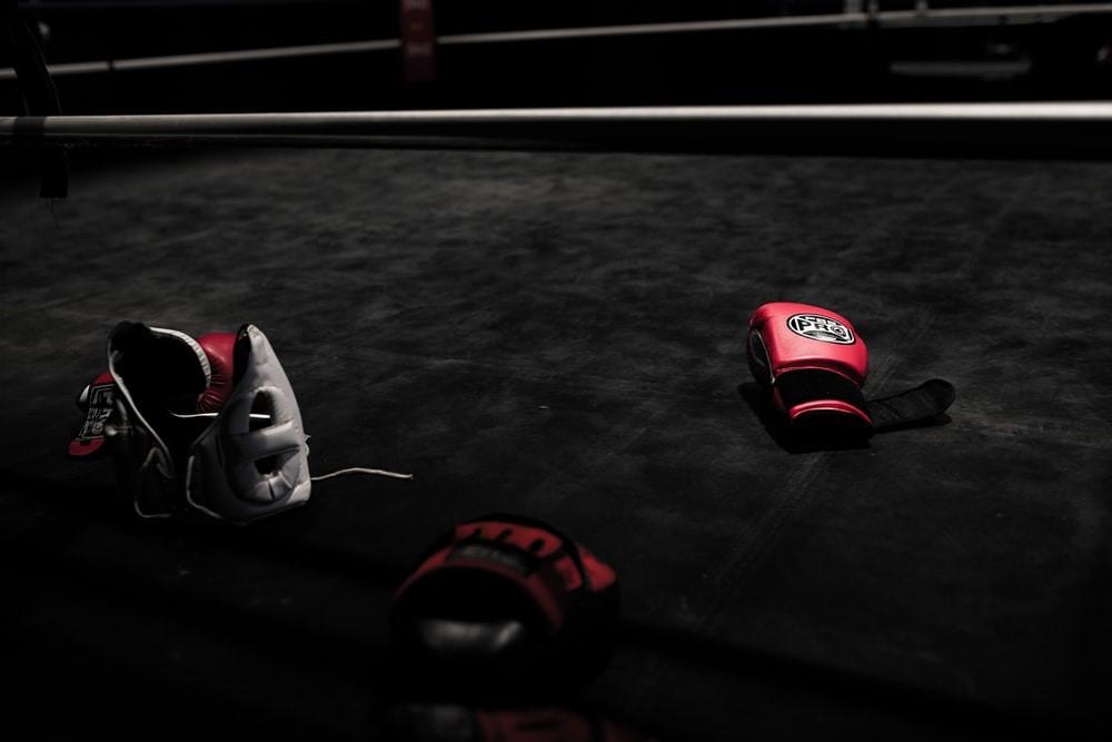 A pair of red boxing gloves in a boxing ring
