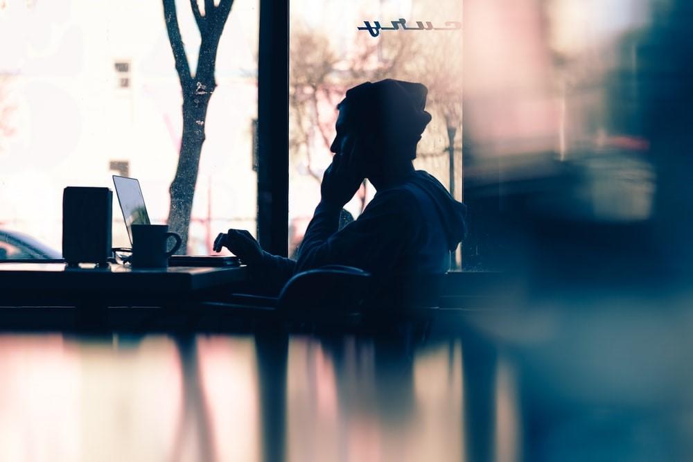 A man working on his laptop in a cafe