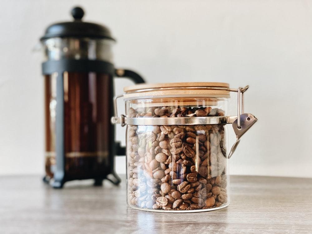 A French press and fresh coffee beans
