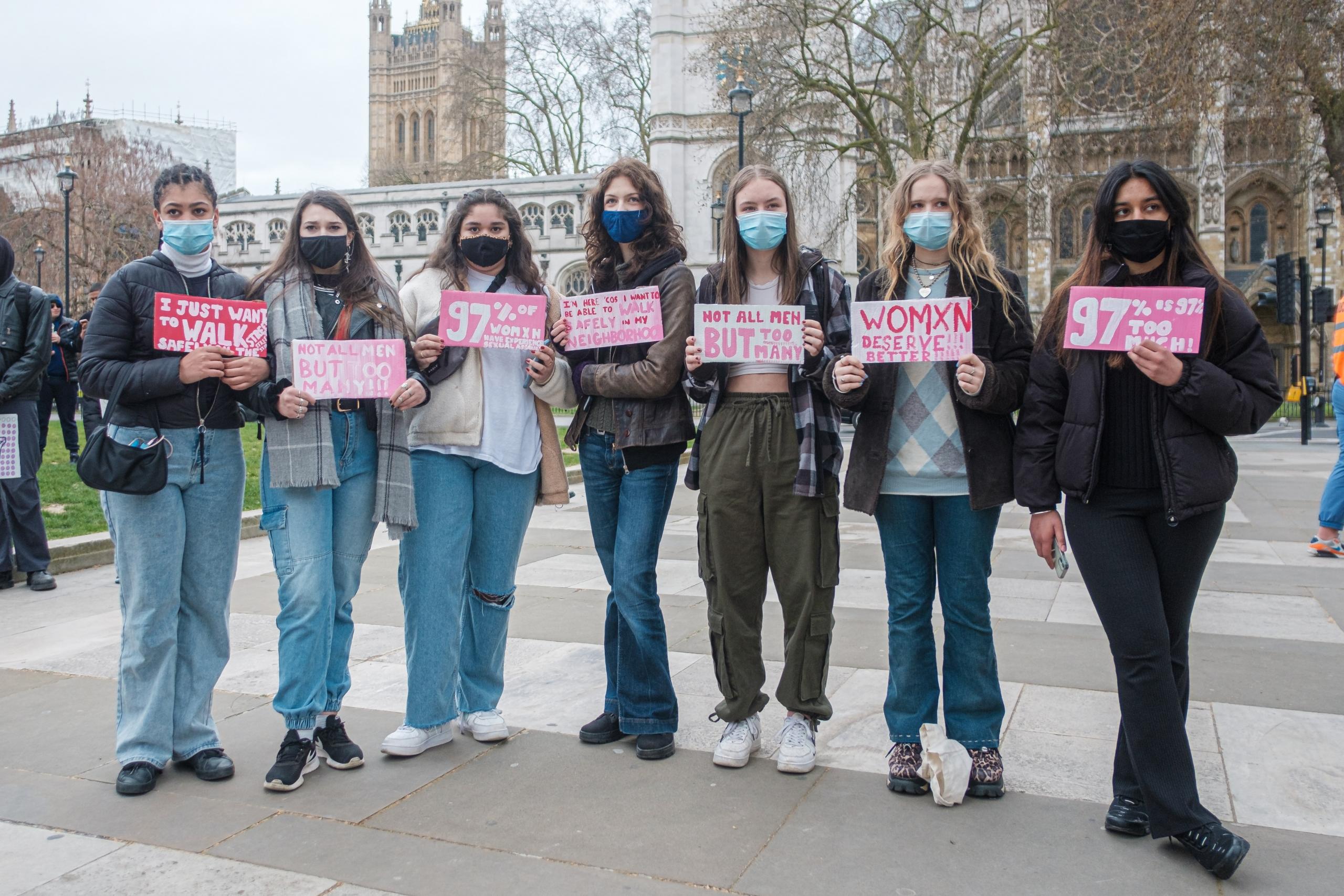 girls in front of university with signs