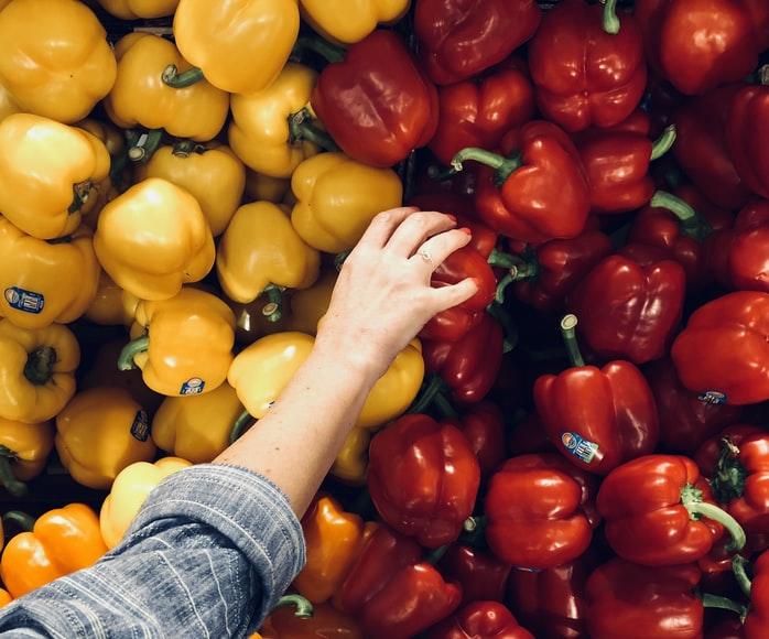 Picking red bell pepper from a combination of yellow and red bell peppers