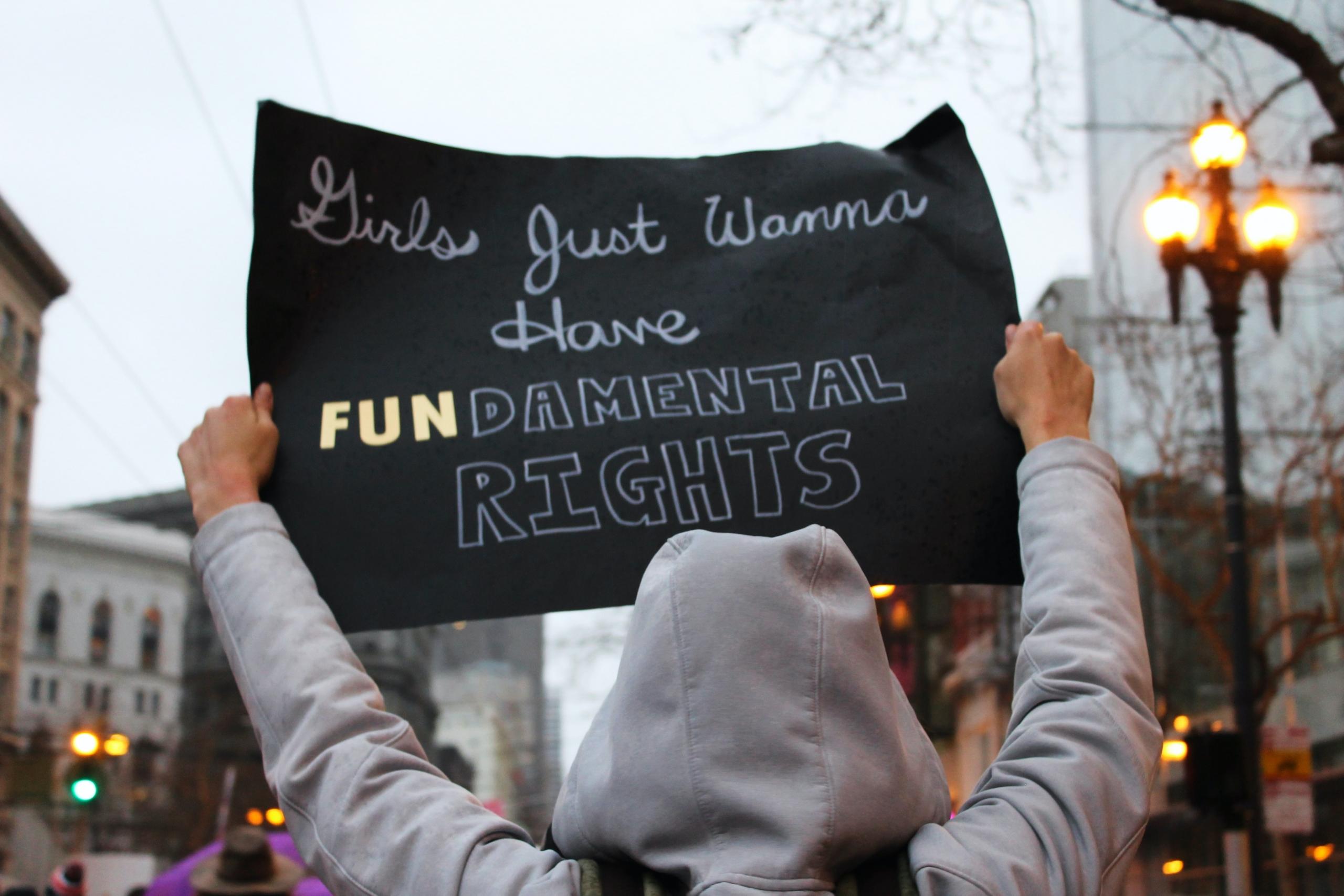 girl holding sign advocating for female rights