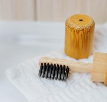 An eco-friendly wooden toothbrush lying on a bathroom towel