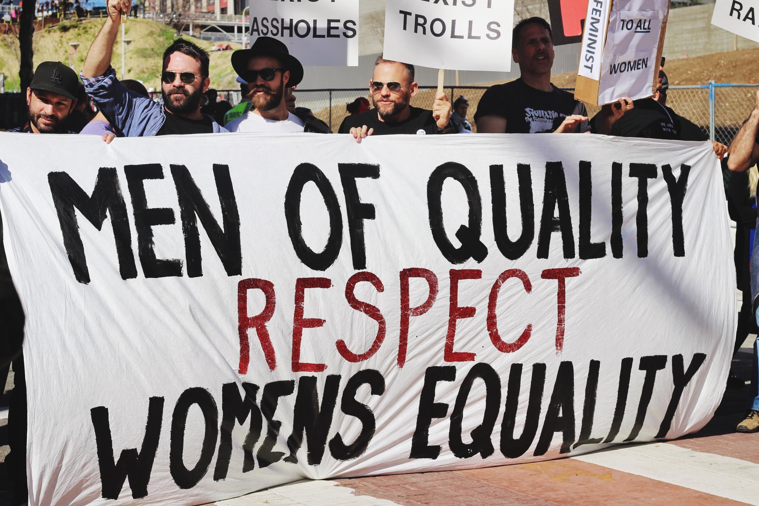 men with a women's equality poster