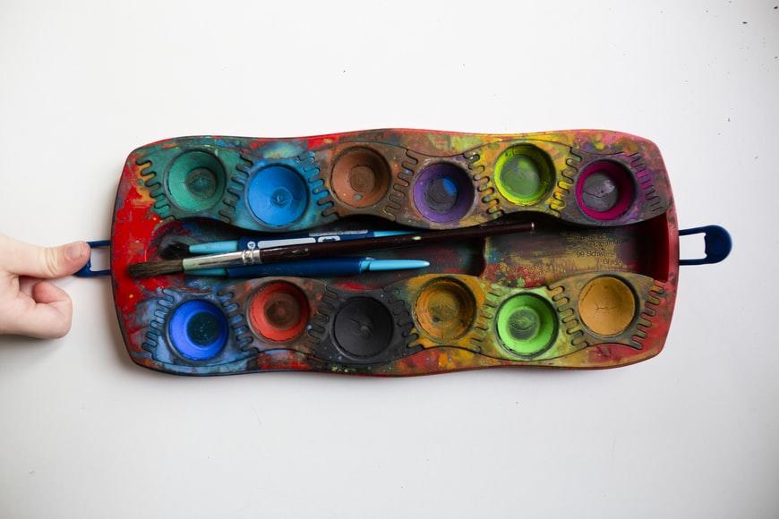 A person holding a watercolors' palette