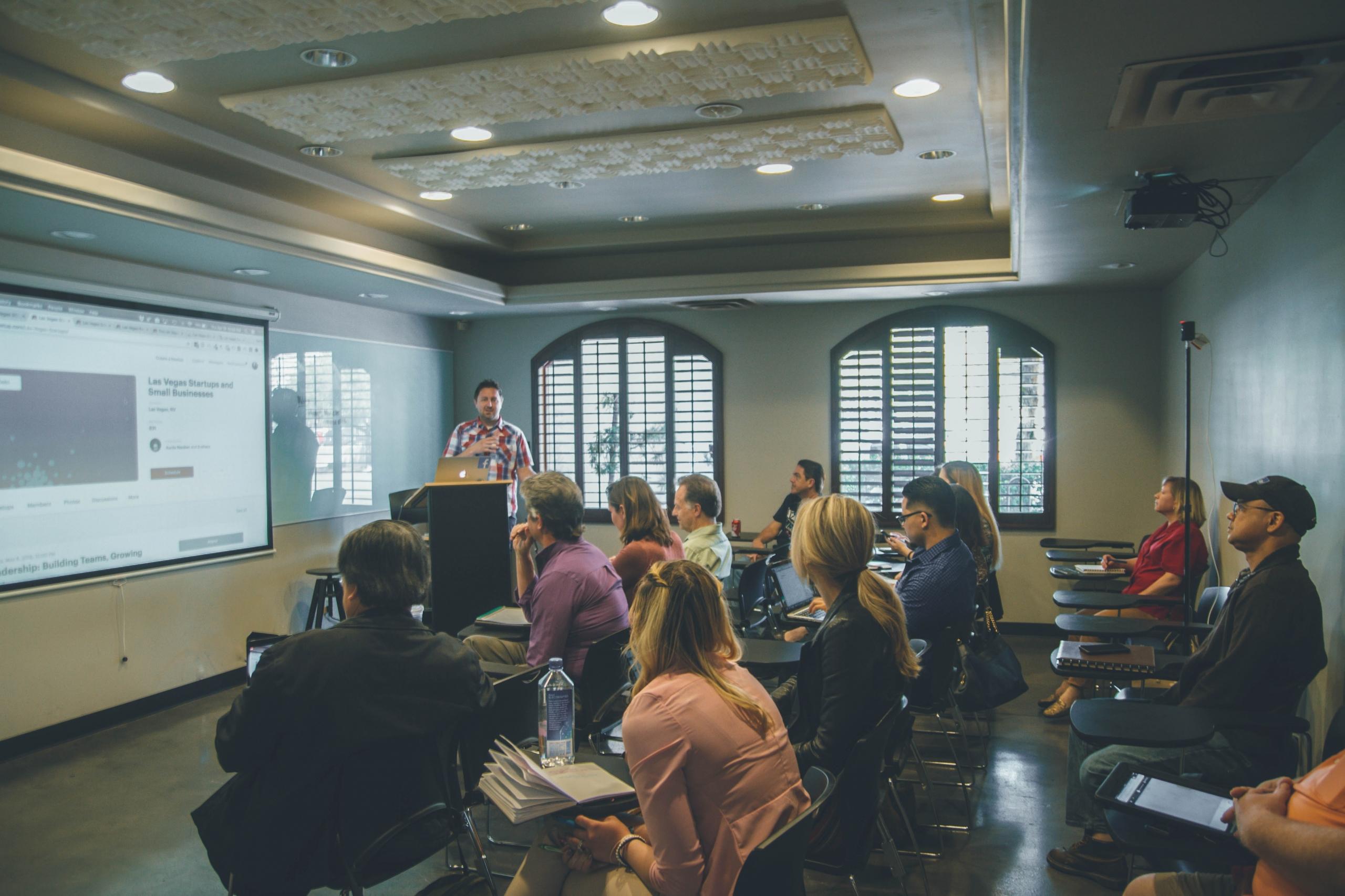 A person giving a lecture to a group of adults