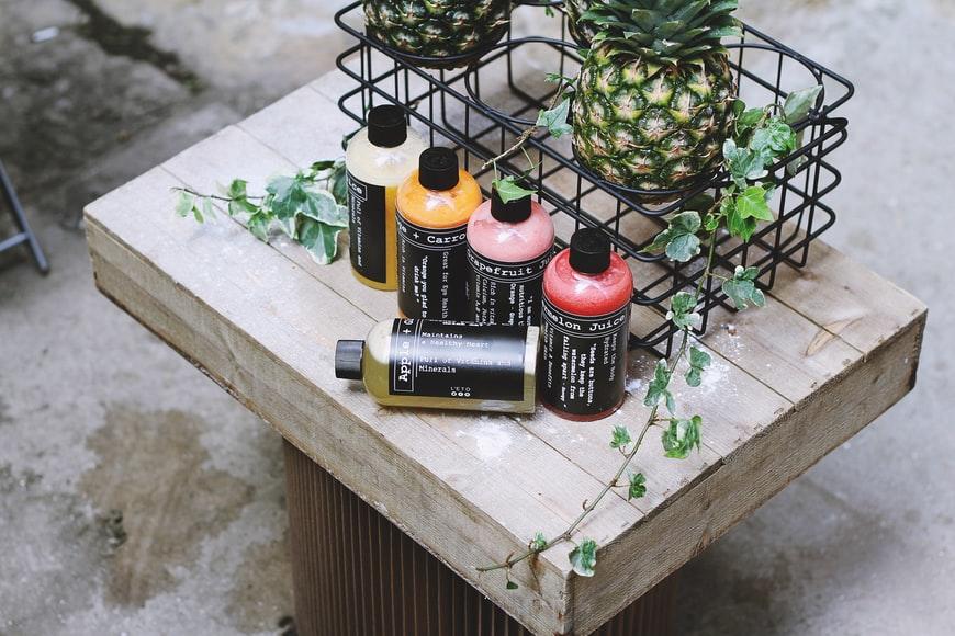 Healthy Rainbow juice bottles lying on a wooden table