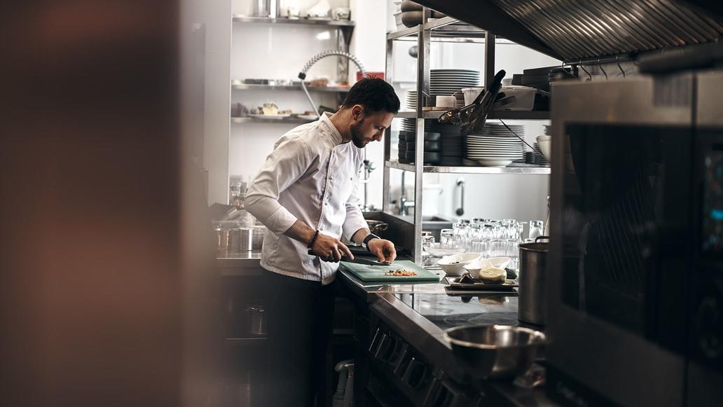 A chef cutting vegetables in a restaurant