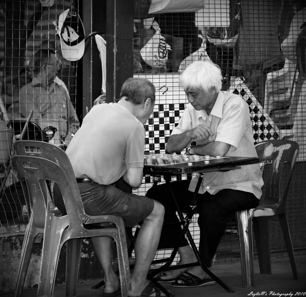 Two older men playing draughts, a rendition of chess
