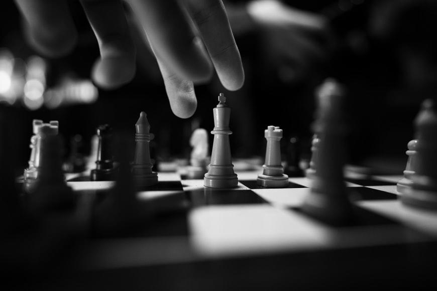 A person moving their king on a chessboard