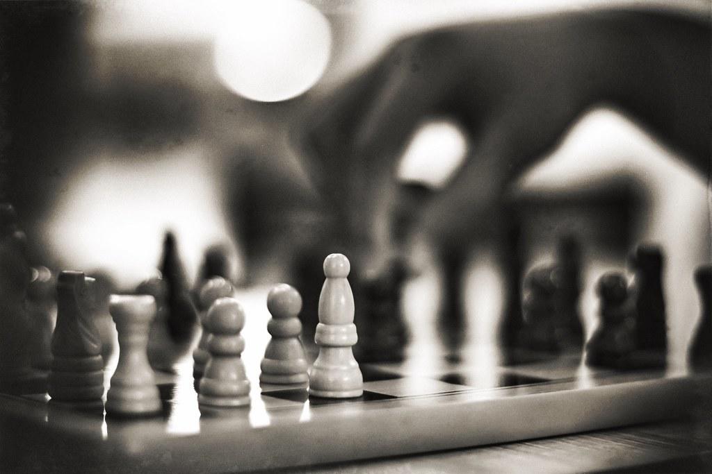 A person moving their black pawn