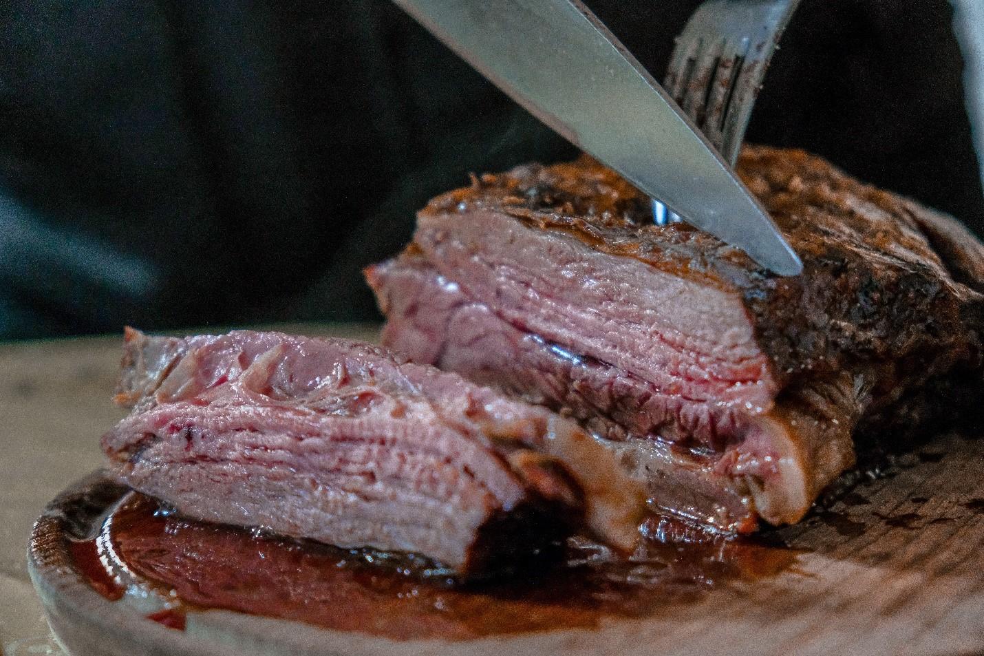 A person cutting roast beef