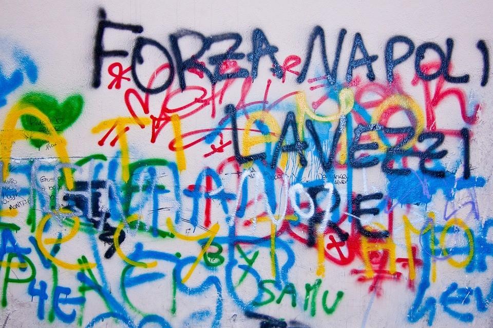Italian words written with spray paint on a public wall as vandalism