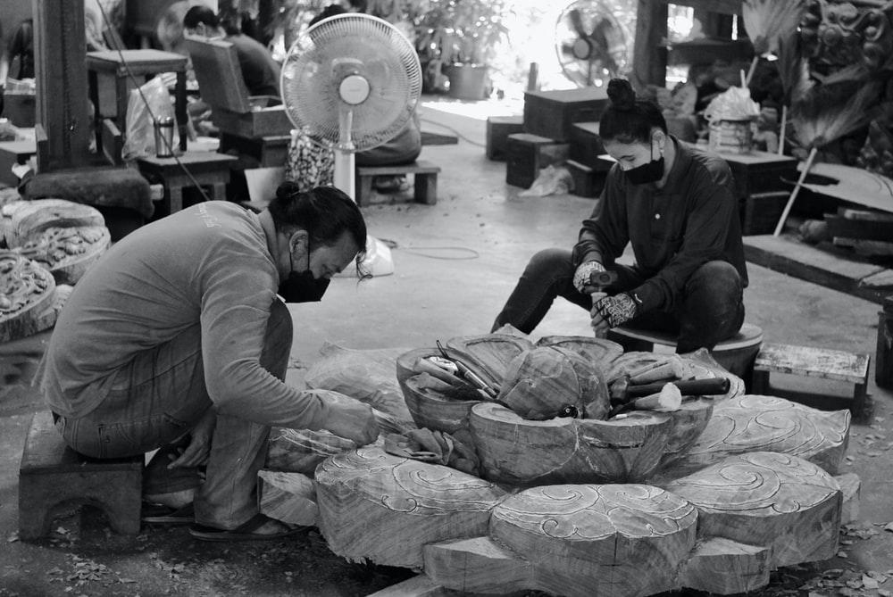 A couple of individuals carving a sculpture