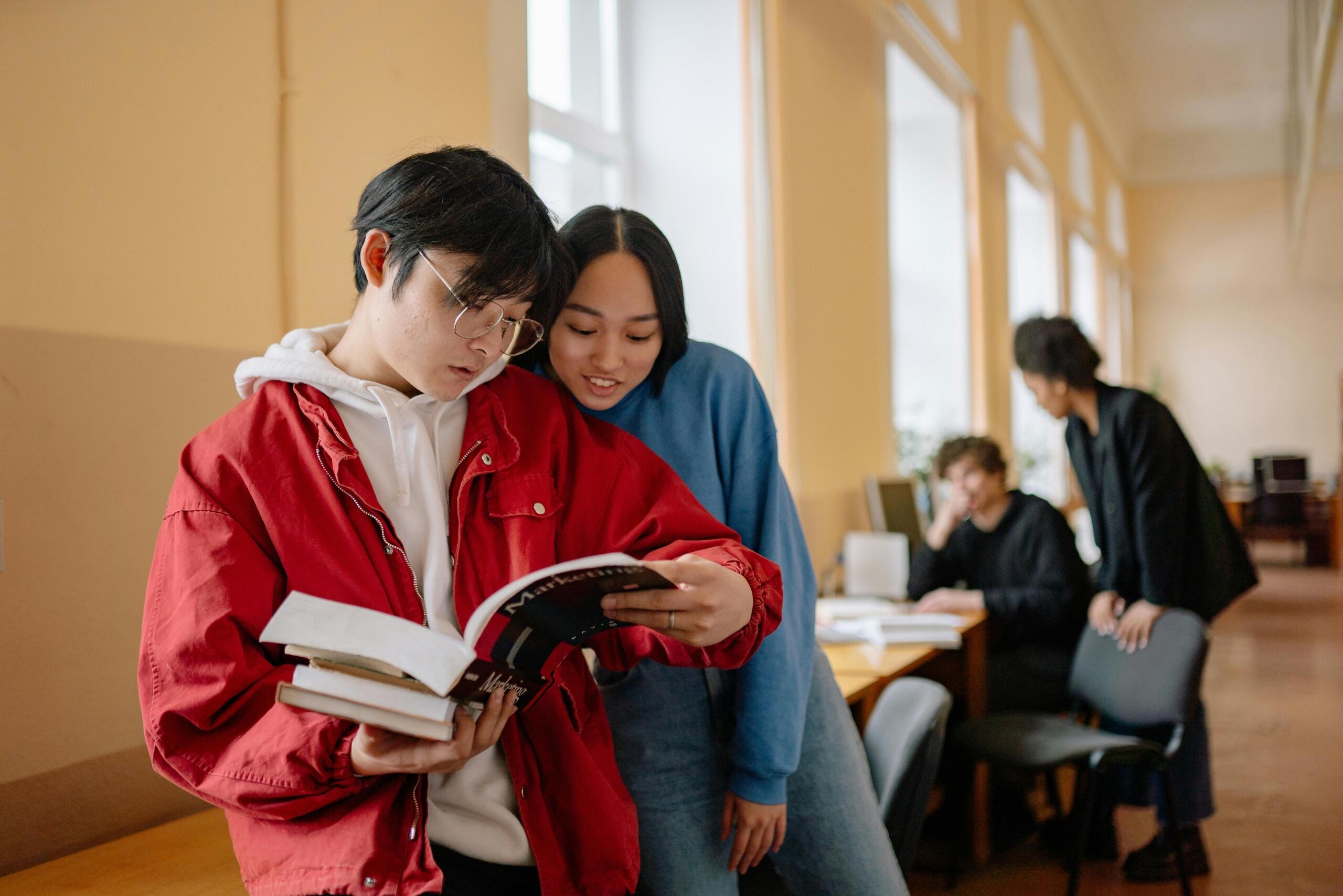 A group of students reading books together, likely engaged in a study session or group discussion.