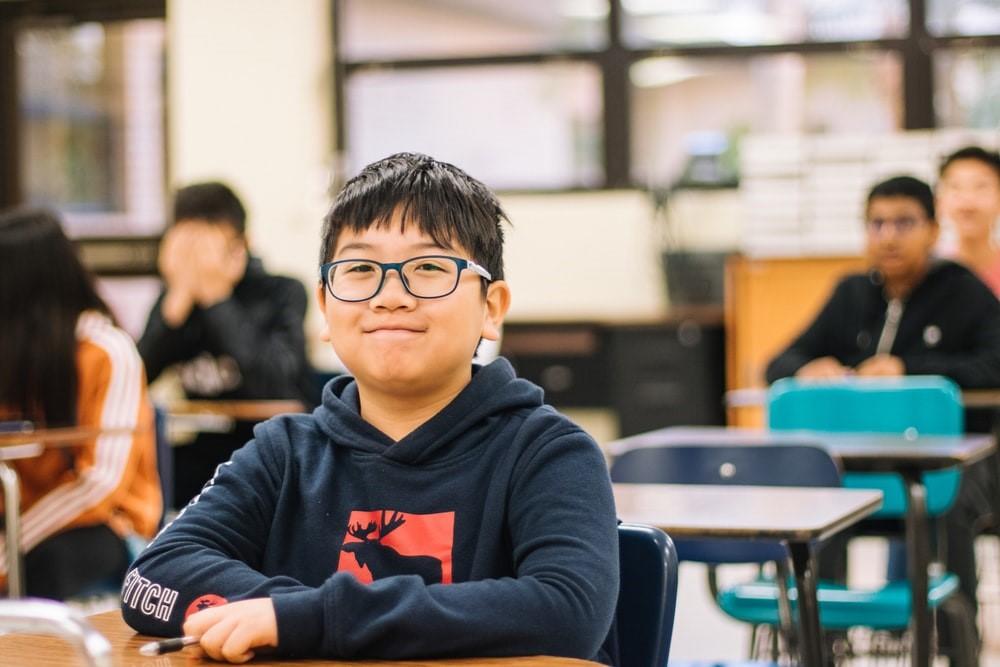 A happy kid learning junior high math with a content smile playing on his lips