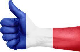 A hand giving thumbs-up is painted in the colors of the French national flag; red, white, and blue from right to left.