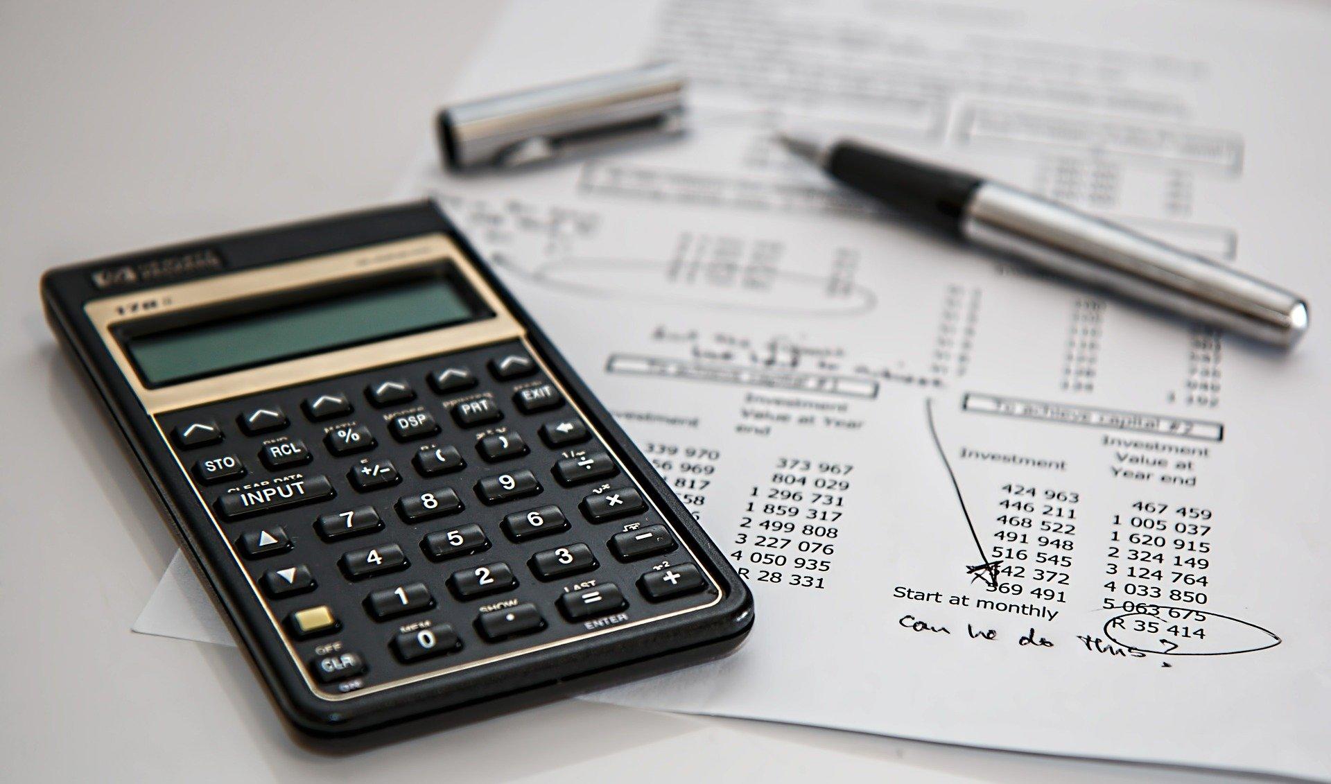 A company's financial reports along with a pen and a calculator