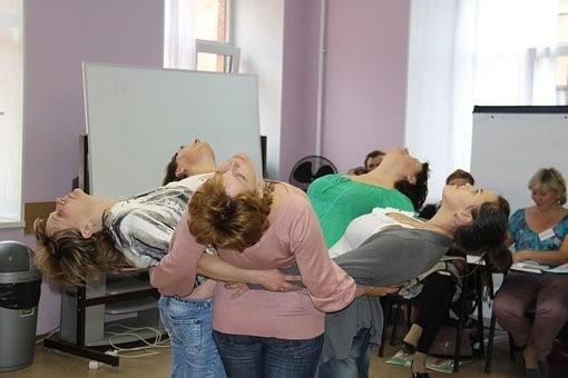 A group of women is receiving art therapy by dancing together