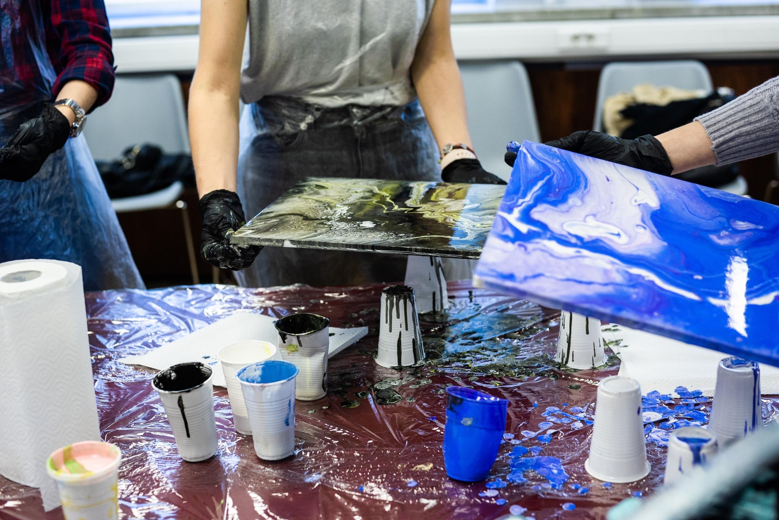 People reviewing their paintings during an art therapy group session