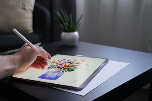 An illustrator designing a vase on a tablet.