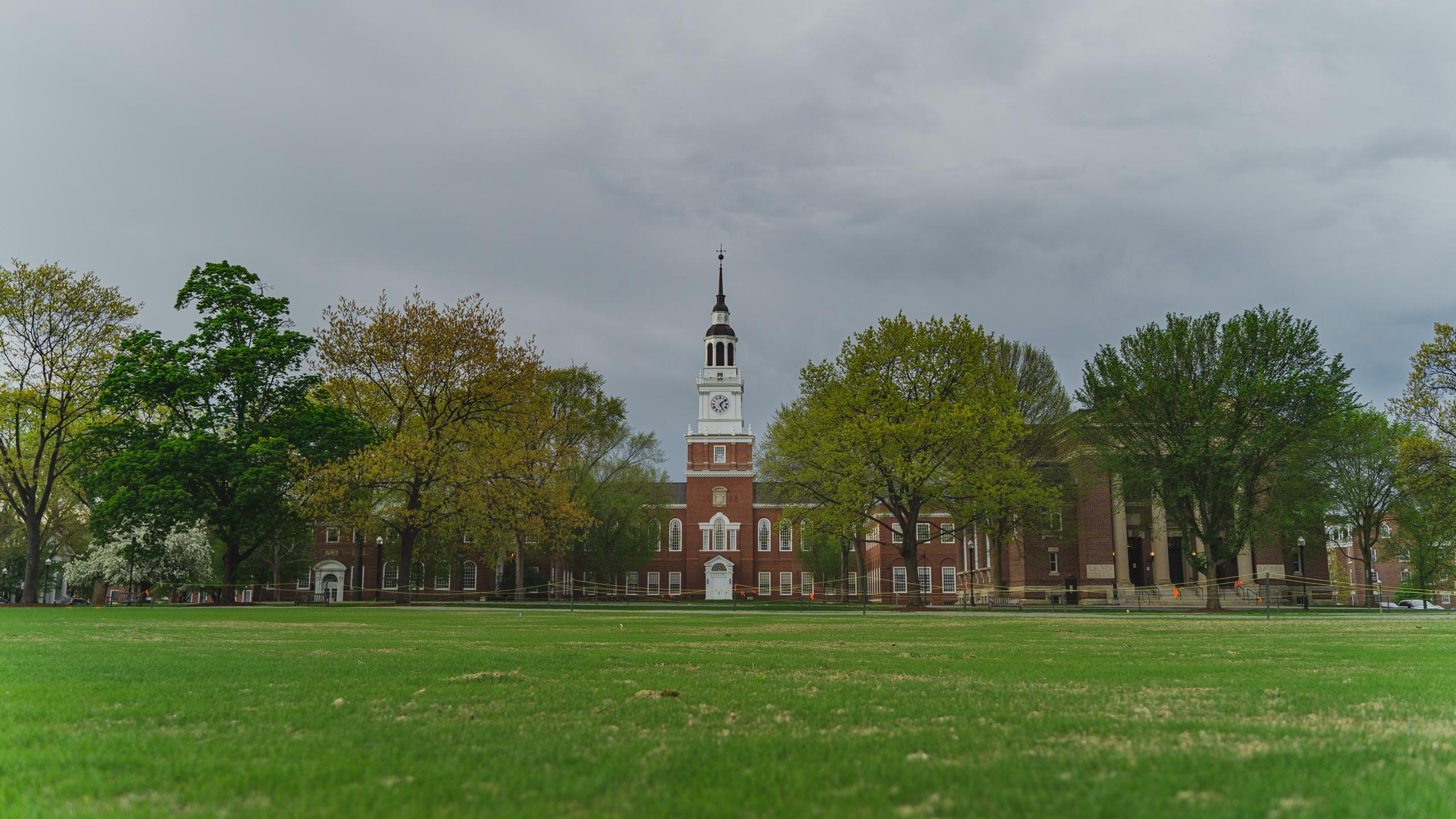 Some trees are covering the front of the Dartmouth College building.