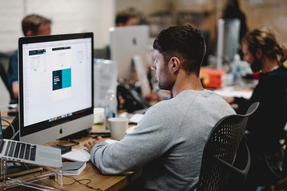 A man using iMac at his workplace