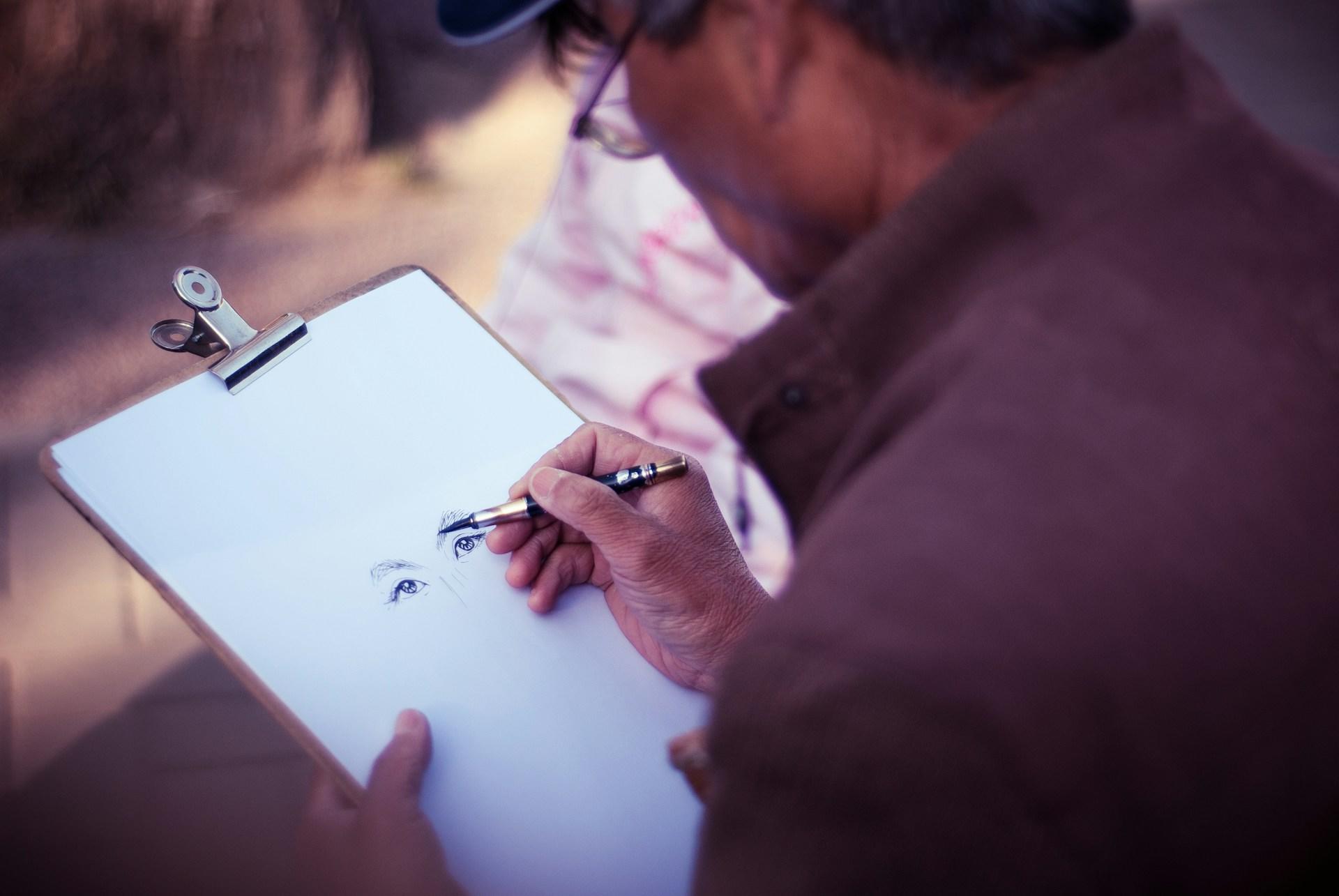 A man drawing a pair of eyes