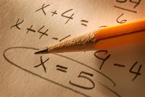 A paper showing a solved maths problem and a pencil on it