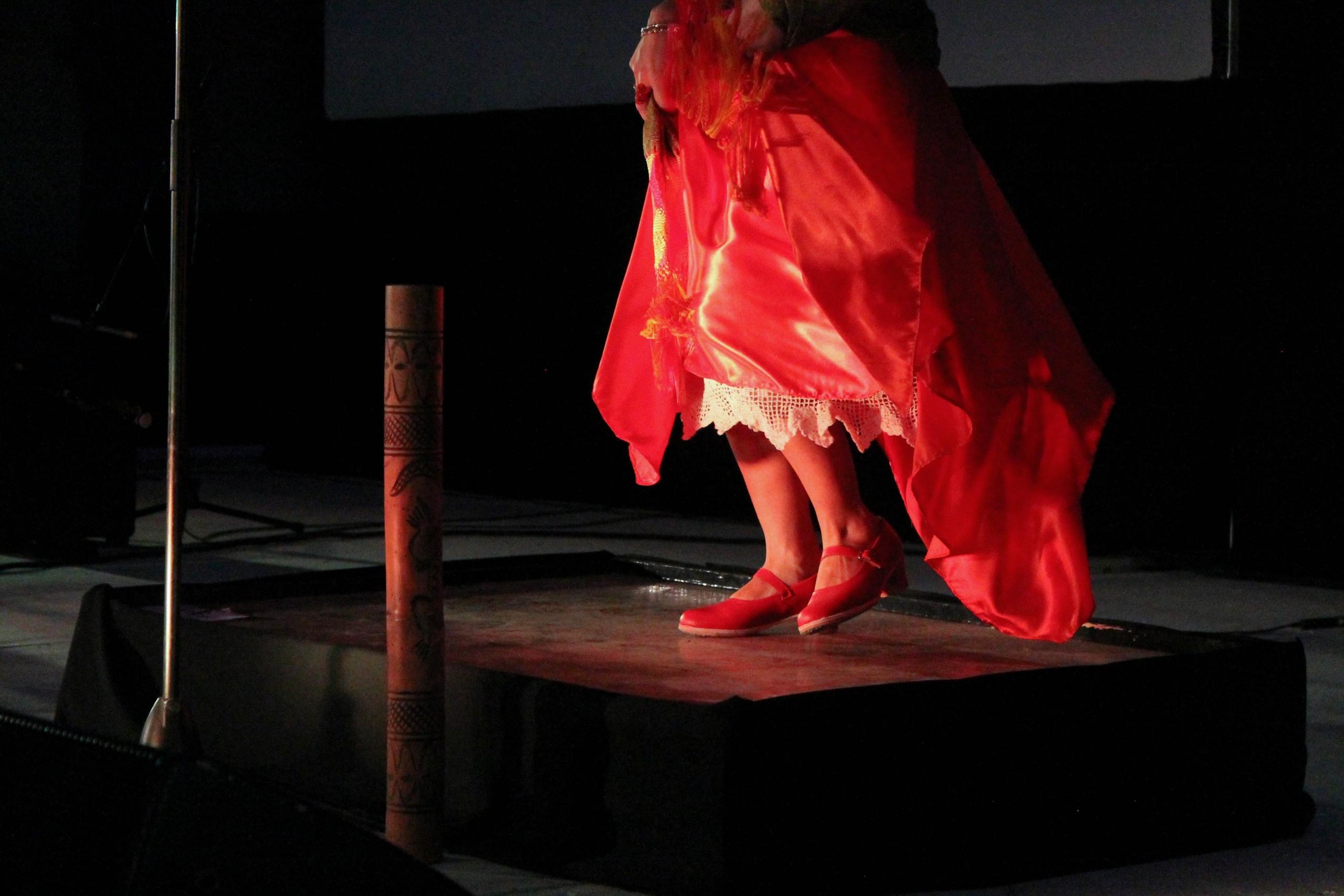 A picture of a flamenco dancer with a red dress and shoes.