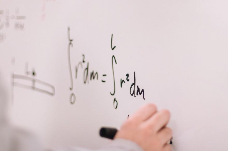 Algebraic equations written on a whiteboard with a marker