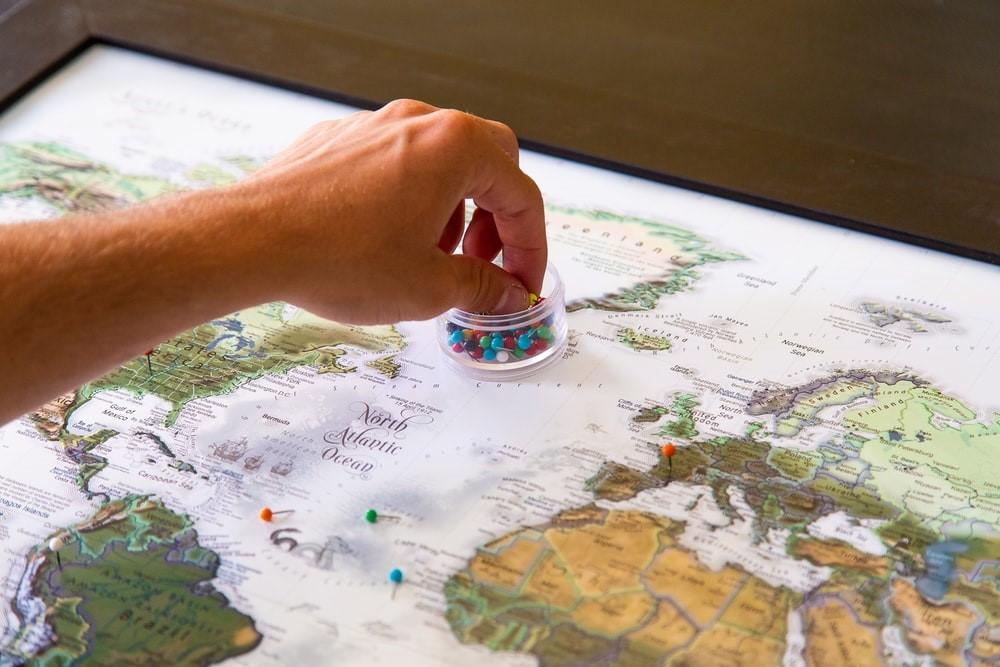 A person marking places with pins on a map of the North Atlantic Ocean