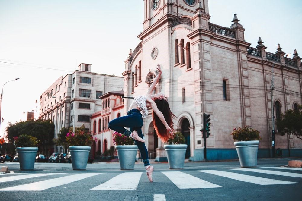 A woman doing ballet dance moves on the street