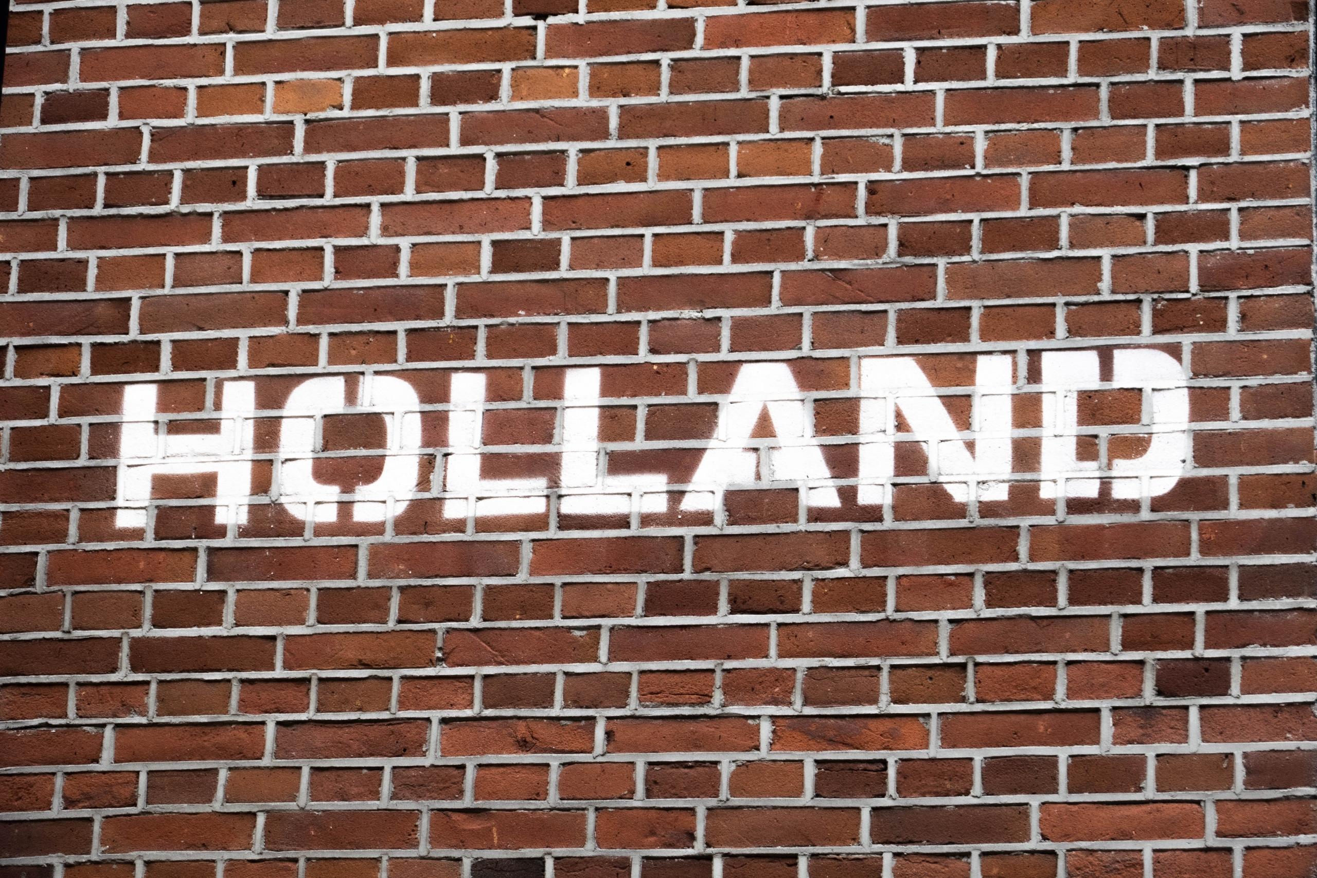 The word Holland is painted on a brick wall in Assen