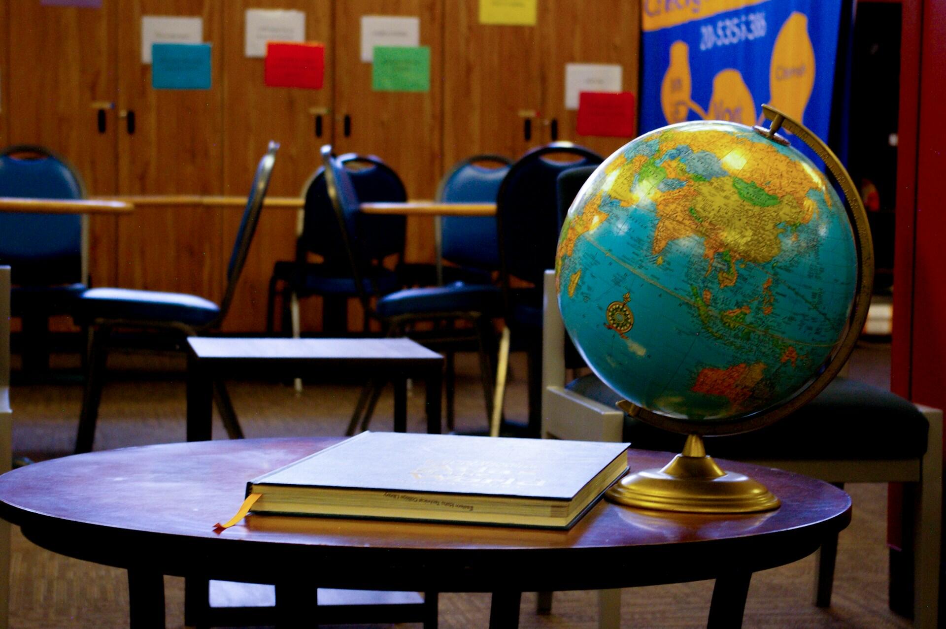 Geography class with a globe on a desk.