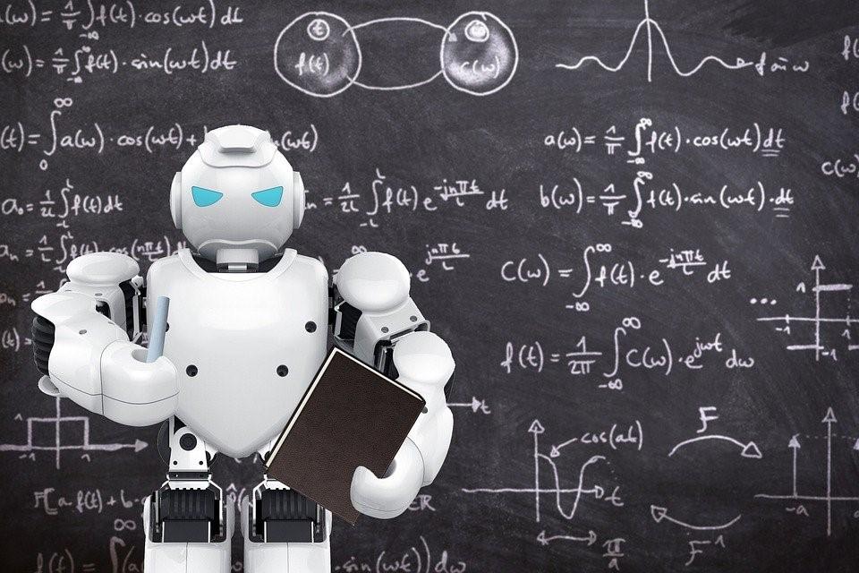 Mathematics and physics formulas jotted down on a blackboard with a robot in front