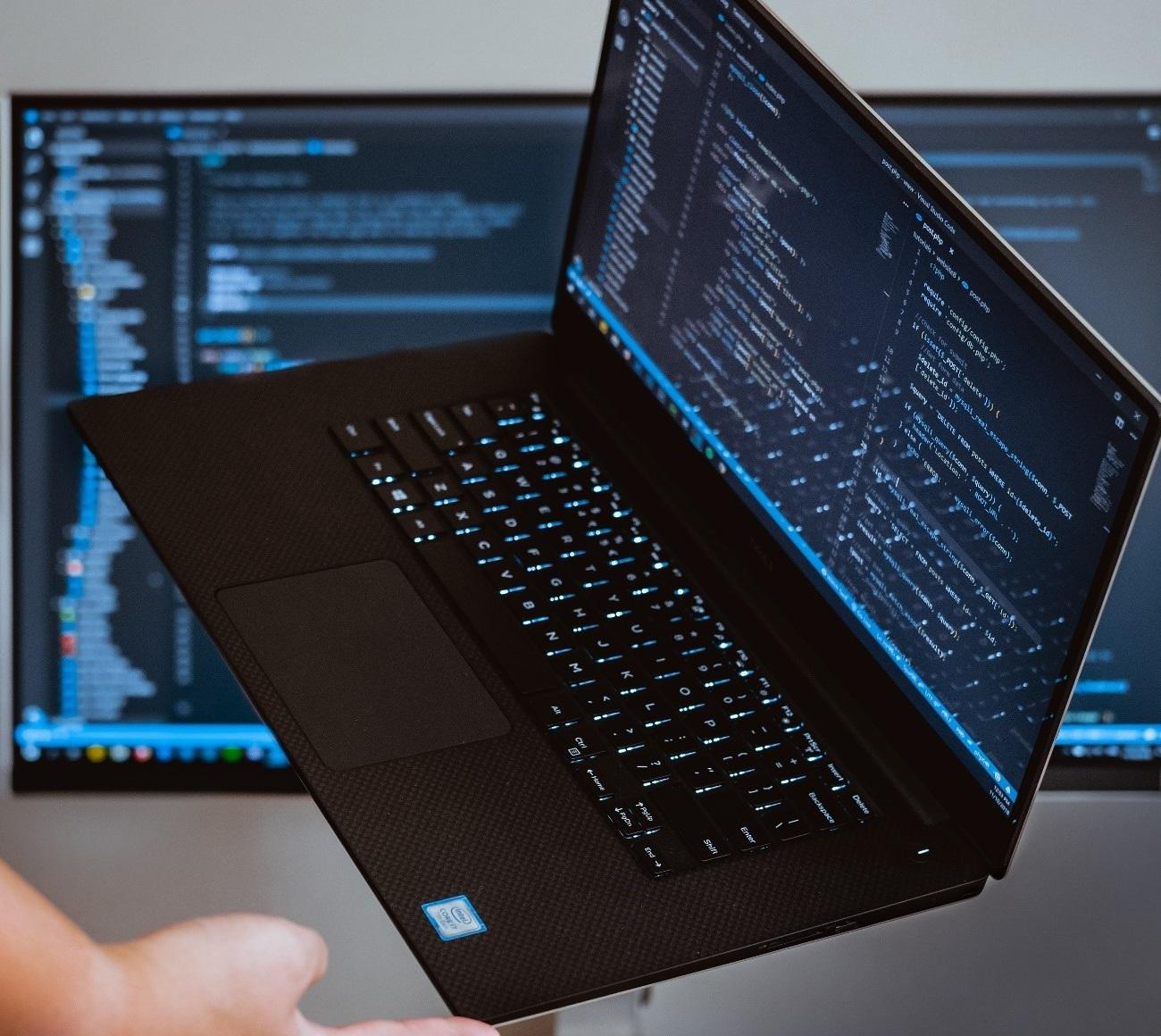 A laptop and PC being used for programming