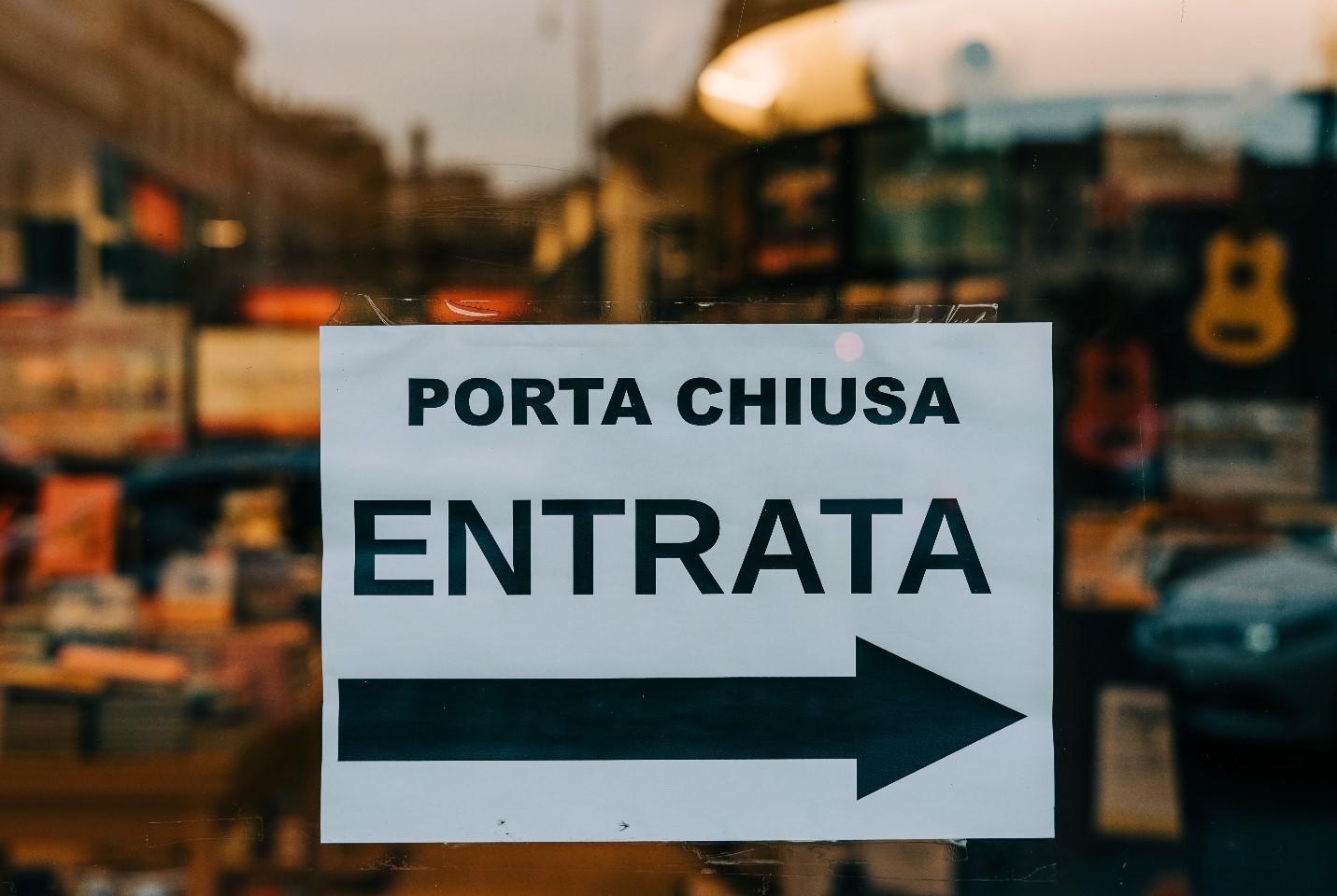 'Porta Chiusa Entrata' in Italian meaning "Front Door Entry" hung on a glass door