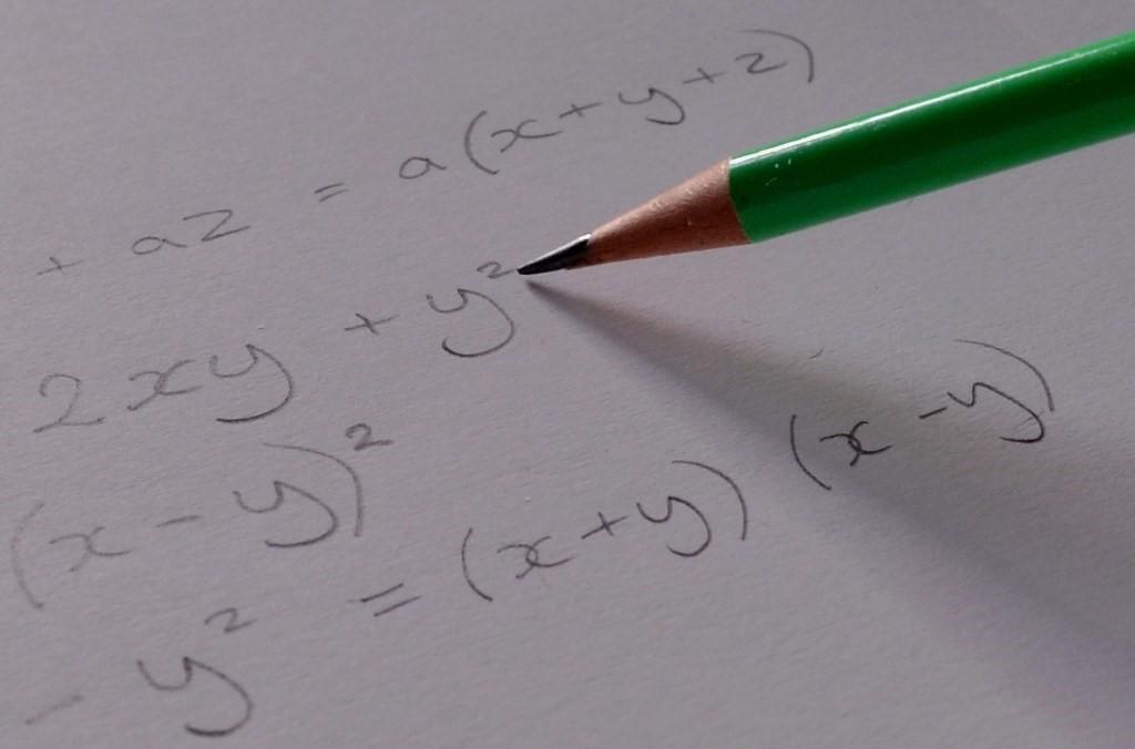 Algebraic formula is written on white paper
