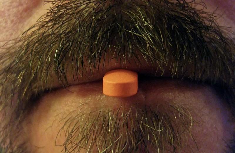 A person ingesting a medicine – the result of years of chemical research