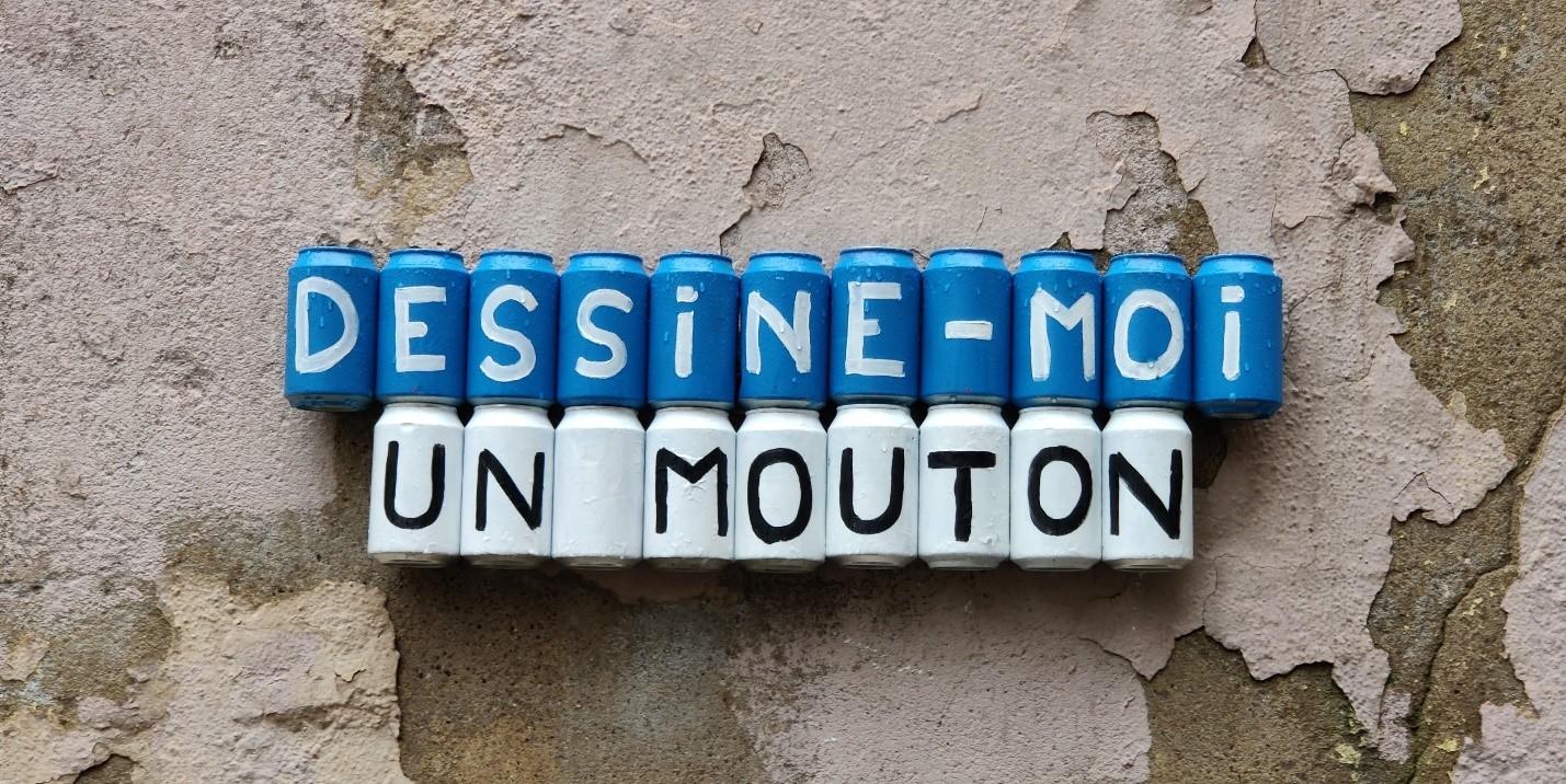 Blue and white cans with a letter on each of them reading out Dessine-Moi Un Mouton, which translates to, ‘draw me a sheep’